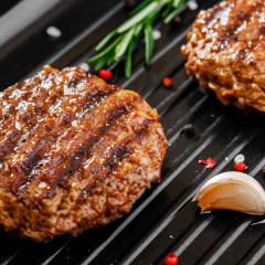 Flame broiled burger patties on grill